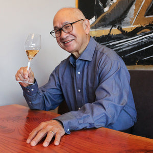Willie Wong sitting at a table with a glass of champagne